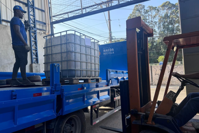 Caminhão carregado com tanques IBC e estruturas metálicas