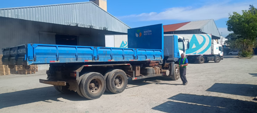Caminhão da Maeda Recicla com colaborador no pátio