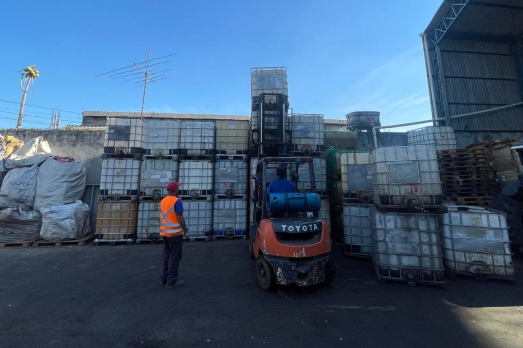 Tanques IBC e empilhadeira no pátio de reciclagem