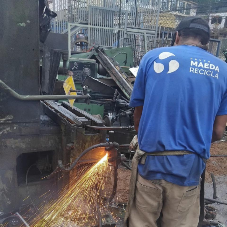 Colaborador da Maeda cortando sucata metálica com maçarico
